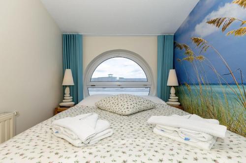 Un dormitorio con una cama con toallas. en Yachthafenresidenz-Wohnung-9303-887, en Kühlungsborn