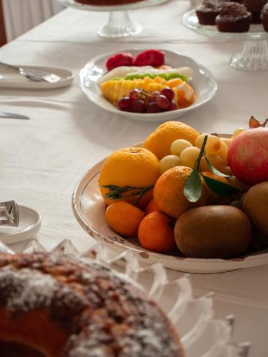 a table topped with plates of fruit and cakes at Masseria Del Crocifisso in Polignano a Mare