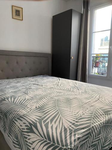 - une chambre avec un lit doté d'une armoire noire et d'une fenêtre dans l'établissement Studio au cœur de Montmartre, à Paris