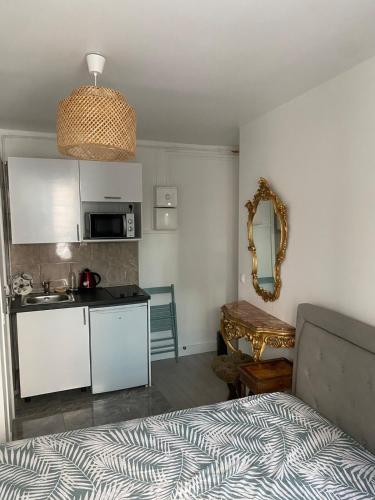 une chambre avec un lit et une cuisine avec un évier dans l'établissement Studio au cœur de Montmartre, à Paris