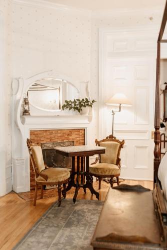 a room with a table and two chairs and a fireplace at Ellerbeck Bed & Breakfast in Salt Lake City