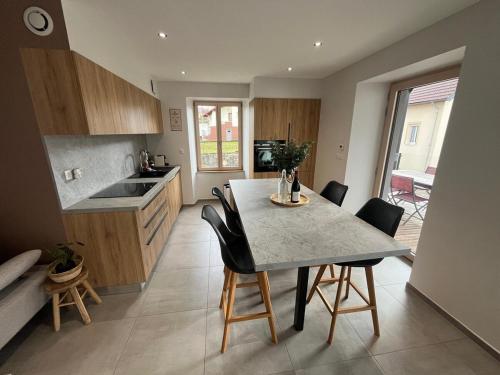 une cuisine avec une table et des chaises dans une pièce dans l'établissement Appartement Pontarlier-centre, à Pontarlier
