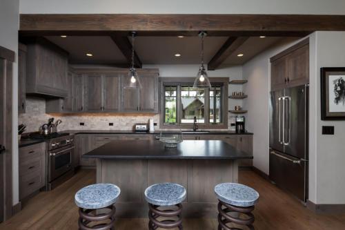 a kitchen with wooden cabinets and a island with bar stools at Lodge at Whitefish Lake in Whitefish