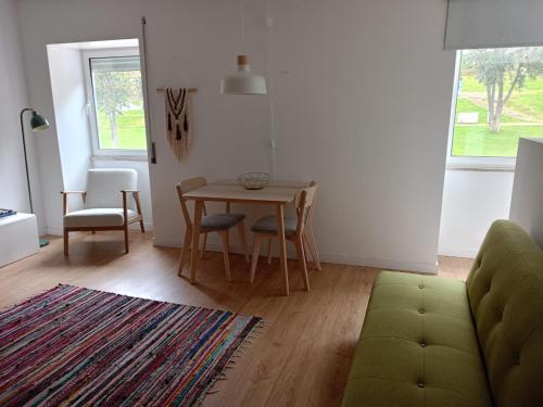 a living room with a table and chairs and a couch at CASA da Corredoura by NaturAlegre in Portalegre