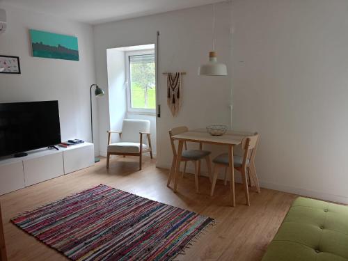 a living room with a table and a television at CASA da Corredoura by NaturAlegre in Portalegre