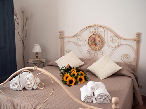 a bed with towels and a bouquet of flowers on it at Masseria Del Crocifisso in Polignano a Mare