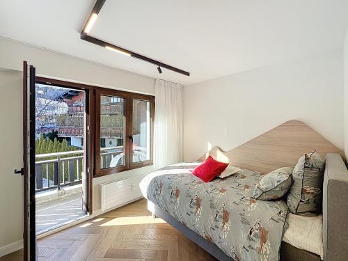 a bedroom with a bed and a large window at La Duchesse in Crans-Montana
