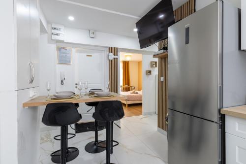 une cuisine avec une table et un réfrigérateur dans l'établissement Meublé 4 Chambres proche du centre, à Clermont-Ferrand