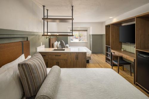 a bedroom with a bed and a kitchen with a sink at River Canyon Lodge in Moab