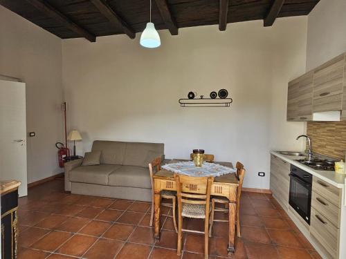 a kitchen and living room with a table and a couch at Home Sweet Home Galatro in Galatro