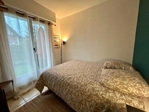 une chambre avec un lit et une grande fenêtre dans l'établissement Havre de paix, à Blonville-sur-Mer