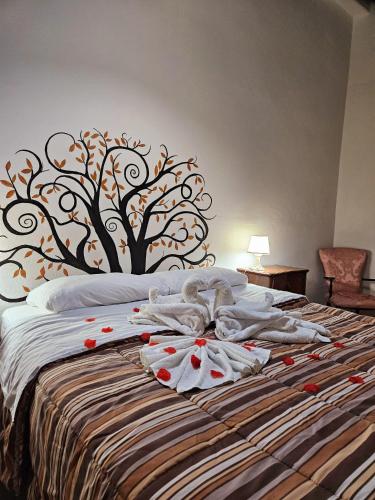 a bed with towels on it with a tree headboard at Home Sweet Home Galatro in Galatro