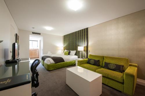 a hotel room with a bed and a couch at City Golf Club Motel in Toowoomba