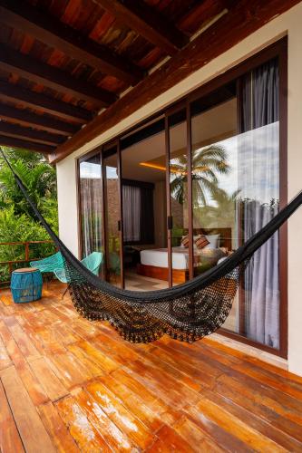 a hammock on a porch of a house at Khaban Bacalar Hotel Boutique in Bacalar