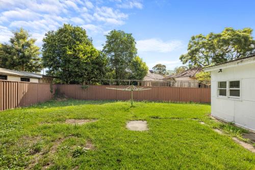 a yard with a batting cage in a fence at Steps to Mall & Train - Eplore with Ease - Prime Location in Seven Hills - Shared Bathroom in Blacktown