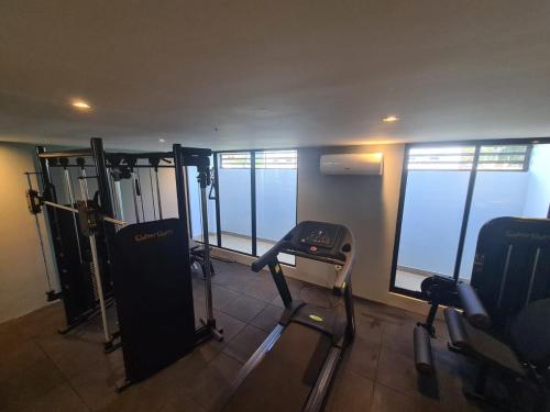 a gym with cardio equipment and windows in a building at Melhores Flats - Excepcional, pertinho do mar in João Pessoa