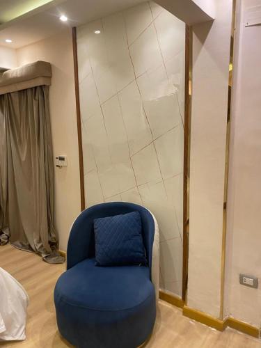 a blue chair with a blue pillow in a room at Rahma Hotel Shehap in Cairo