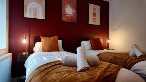 two beds in a room with red walls at City Center 1 Bed Flat in Peterborough