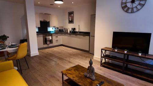 a living room with a couch and a television and a table at City Center 1 Bed Flat in Peterborough