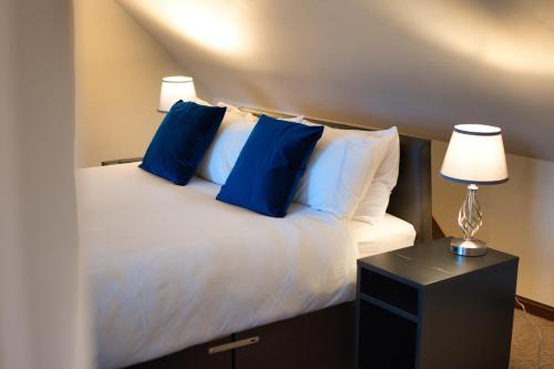 a bedroom with a bed with blue pillows and a table at Clifton House Brighton in Portslade