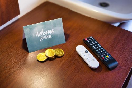 a remote control and two coins on a table at Clifton House Brighton in Portslade