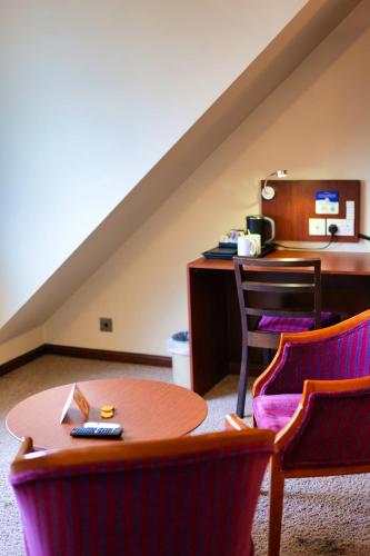 a room with a table and chairs and a desk at Clifton House Brighton in Portslade