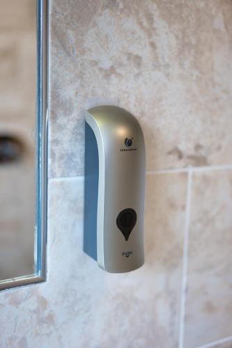a soap dispenser on a wall in a bathroom at Clifton House Brighton in Portslade