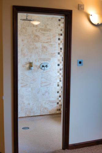 a glass door of a bathroom with a stone wall at Clifton House Brighton in Portslade