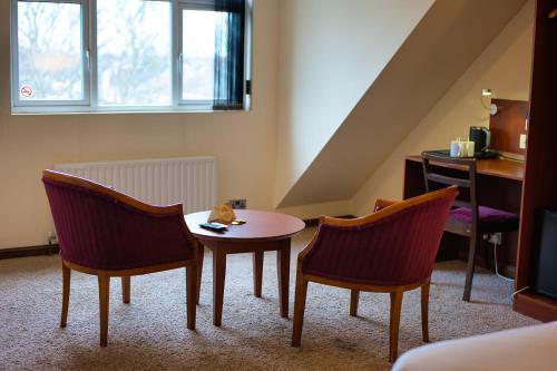 a living room with a table and two chairs at Clifton House Brighton in Portslade