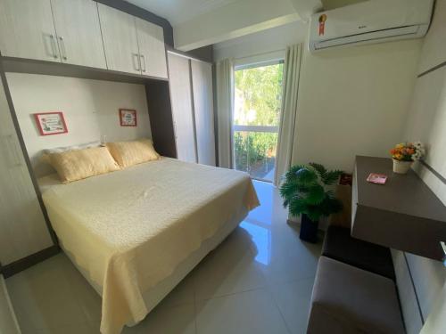 a small bedroom with a bed and a window at Lindo Apto 404 bem localizado Piratuba SC in Piratuba