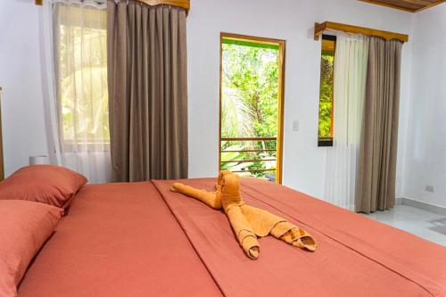 a stuffed animal laying on top of a bed at Corcovado & Drake Inn in Drake
