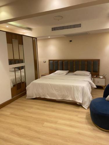 Un dormitorio con una gran cama blanca en una habitación. en Aw Suites, en Giza