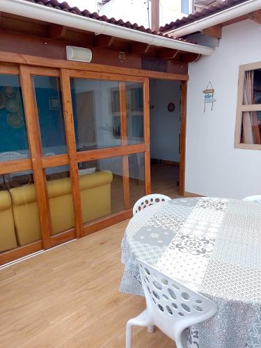 a patio with a white table and chairs on it at VIVEMAR PUNTA HERMOSA - Beach House Lima - Perú in Punta Hermosa