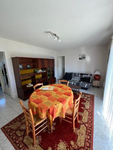 une chambre avec une table et des chaises et un salon dans l'établissement Appartement 3 pièces Royan, à Royan
