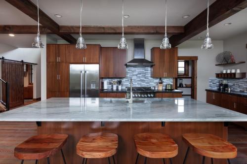 a kitchen with a large island with wooden stools at Lodge at Whitefish Lake in Whitefish