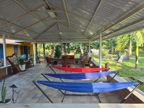 a patio with blue and red hammocks under a roof at Mirador San Miguel in San José del Guaviare