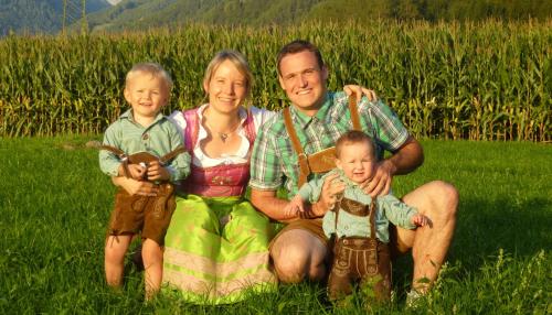 a family posing for a picture in a field at Winklerhof Apartments in Brunico