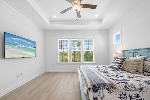 a bedroom with a bed and a ceiling fan at Sandy Cheeks in Orange Beach