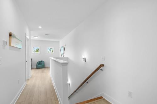 a white hallway with white walls and a stairway at Sandy Cheeks in Orange Beach
