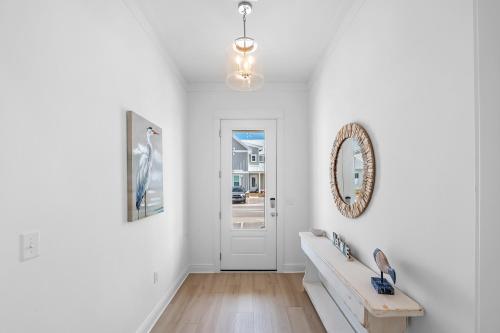 a white living room with a mirror on the wall at Sandy Cheeks in Orange Beach
