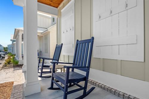 two blue chairs sitting on the porch of a house at Sandy Cheeks in Orange Beach