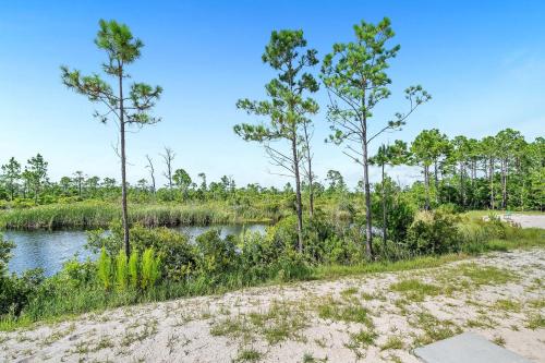 a dirt road next to a river with trees at Sandy Cheeks in Orange Beach