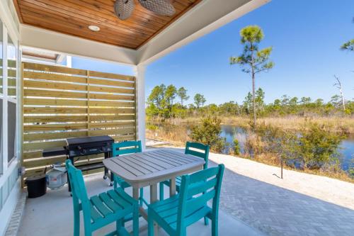 a table and chairs on a porch with a view of a lake at Sandy Cheeks in Orange Beach