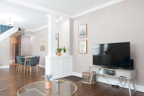 een woonkamer met een grote televisie en een tafel bij Adorable Broad Ripple Duplex in Indianapolis