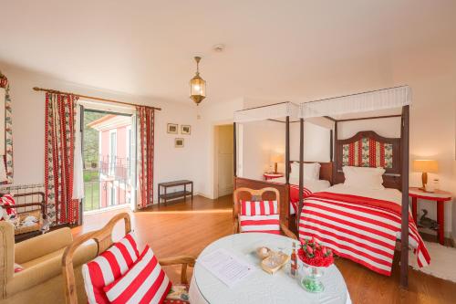 a bedroom with a canopy bed and a table and chairs at Casa da Ria - Turismo Rural in Ílhavo