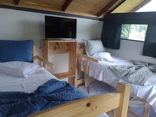 een kamer met 2 stapelbedden en een flatscreen-tv bij Chalé Duplex monte fuji ubatumirim in Ubatuba