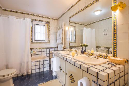 a bathroom with a sink and a tub and a toilet at Casa da Ria - Turismo Rural in Ílhavo