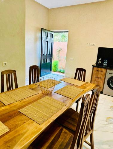 a dining room with a wooden table and chairs at Villa Nadia Marrakech in Marrakech
