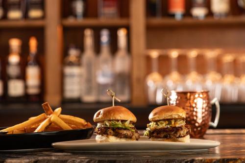 two hamburgers and fries on a plate with a cup of coffee at Allred Hotel in Newport