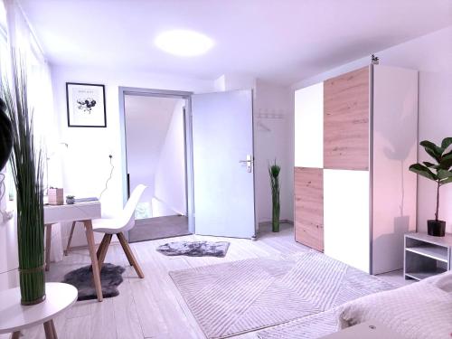 a white room with a desk and a room with a door at Apartment AlbGlück 2 Hechingen in Hechingen